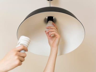 Woman replacing light bulb at home. Power save LED lamp changing Woman replacing light bulb at home. Power save LED lamp changing